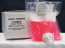 clear packet, pink liquid, resting against case with label